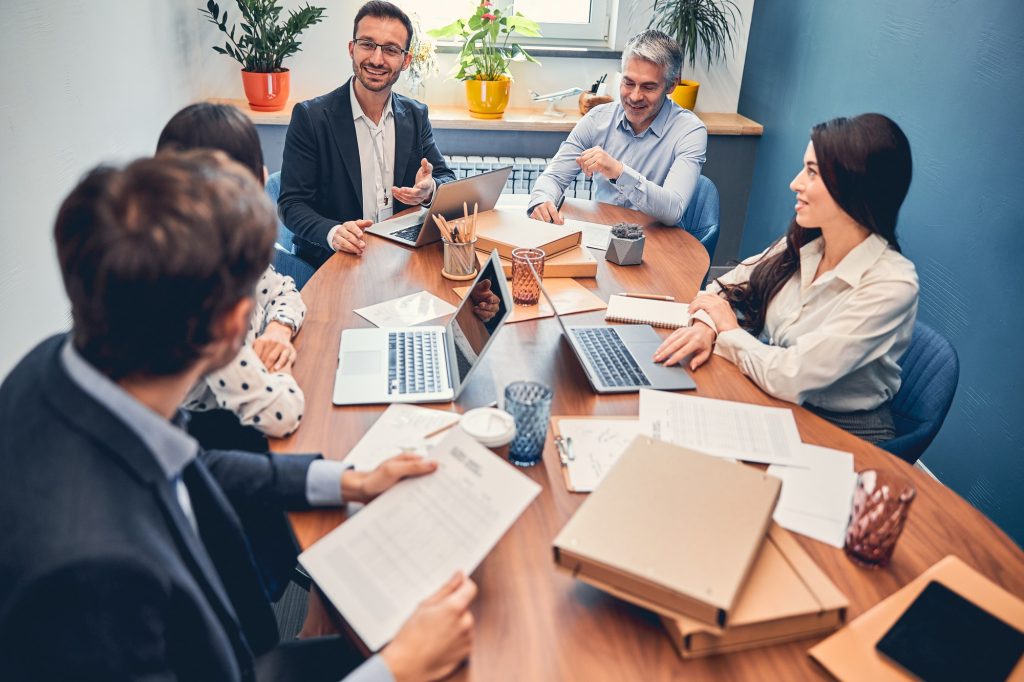 Grupo de profesionales reunidos en torno a una mesa de trabajo, representando la coordinación institucional entre comunidades autónomas